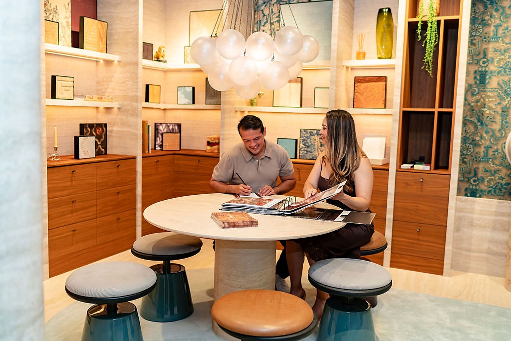 Gisele Cano of The Style Maison meeting with a client over wallcovering books at a showroom table