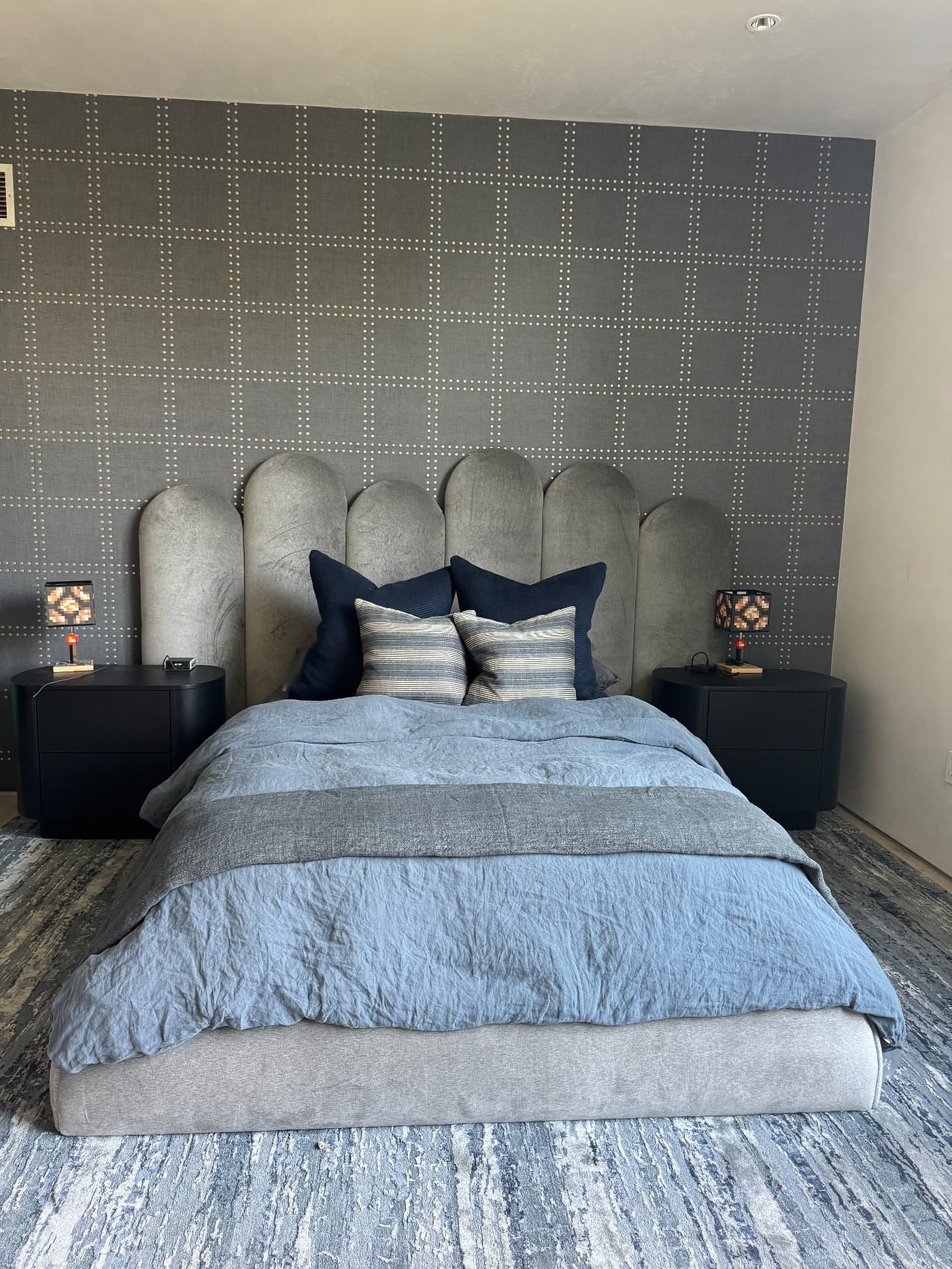 Primary bedroom with a textile grid wallcovering behind the bed, installed by The Style Maison