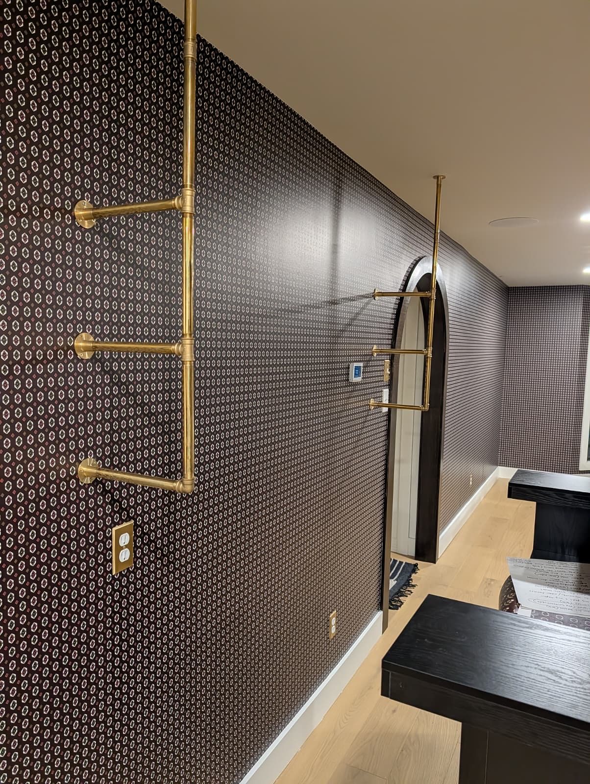 Hallway with a geometric accent wall and brass details, installed by The Style Maison