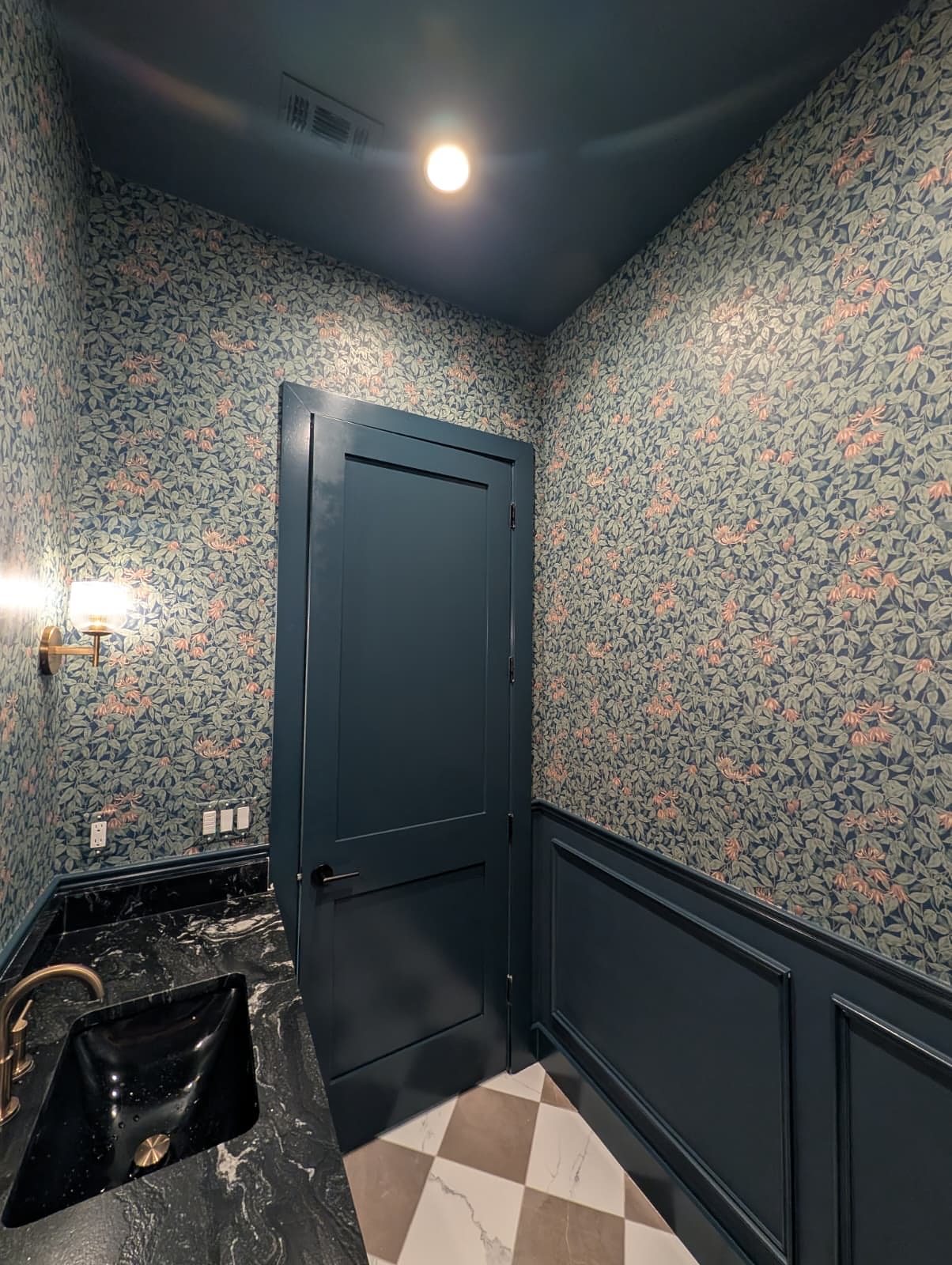 Powder room with floral wallpaper and dark paneling, installed by The Style Maison