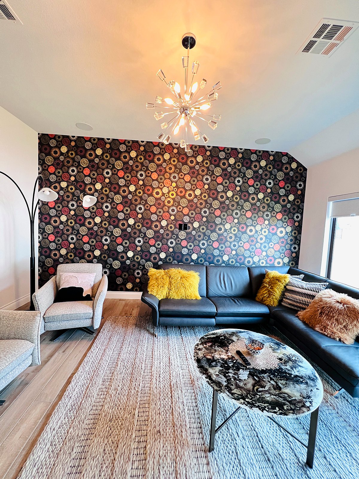 Floral accent wall behind a sectional sofa, installed by The Style Maison