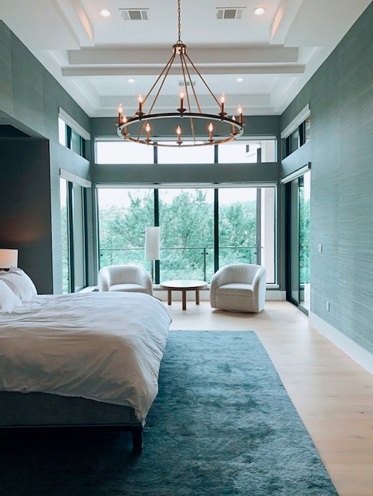 Grasscloth behind a bed in a primary bedroom