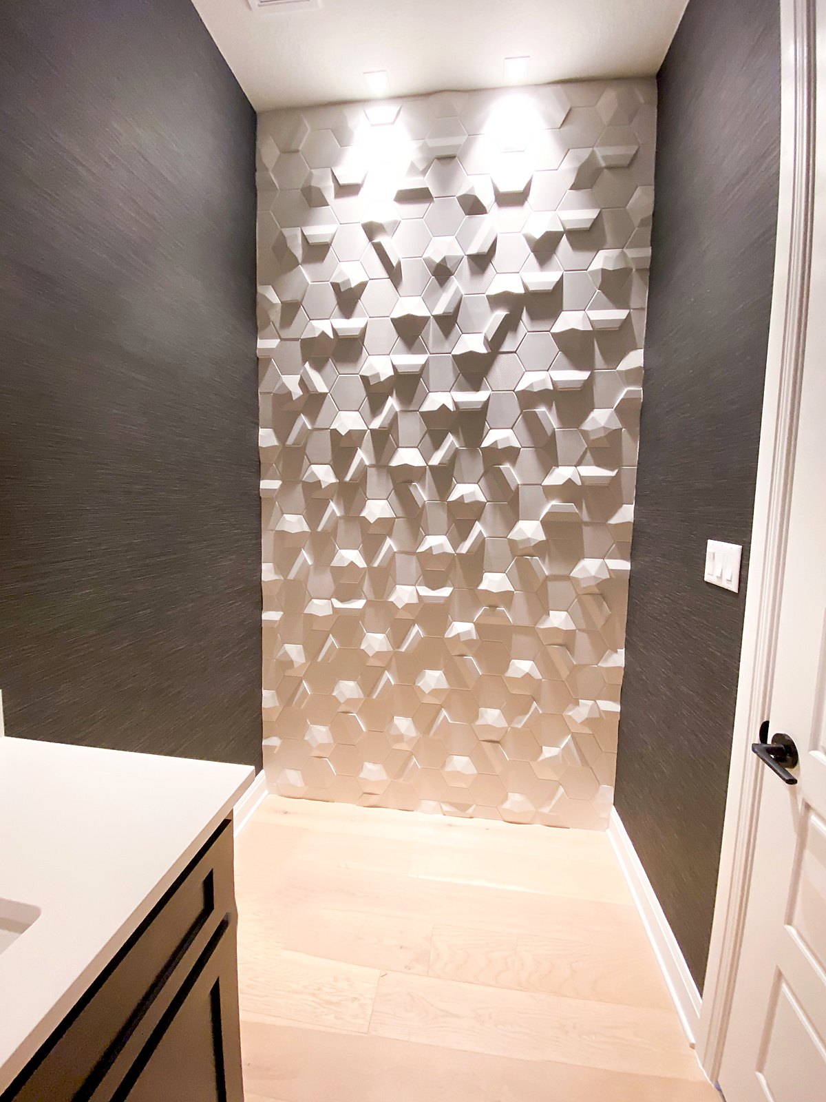 Textured grasscloth wall beside a sculptural 3D feature wall