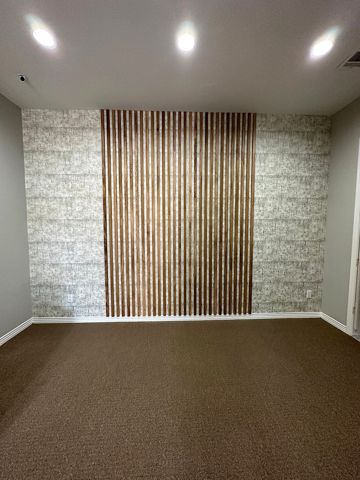Wallpaper with a wood slat feature in a small office