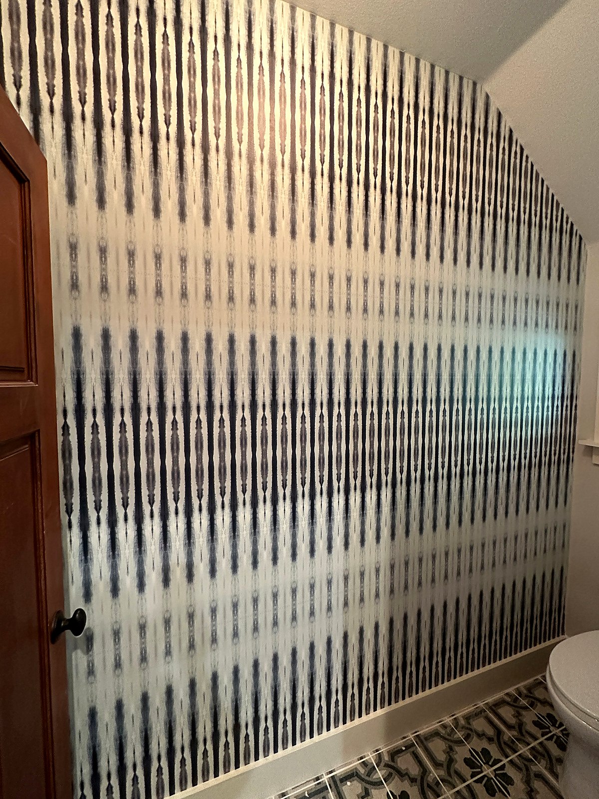 Ikat-style wallpaper running under a sloped ceiling